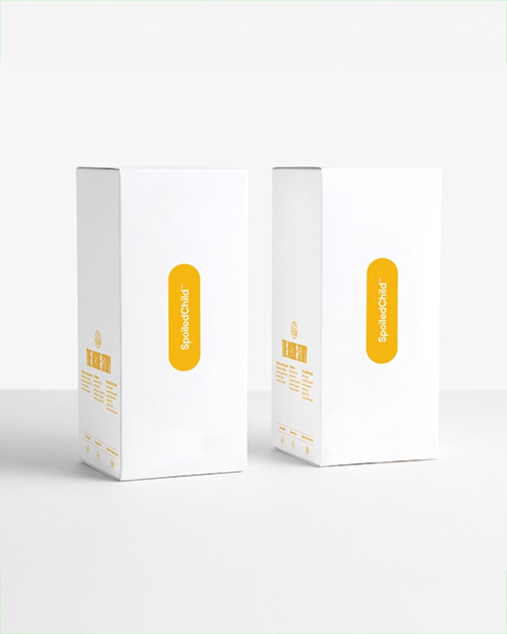 Two white SpoiledChild product boxes with yellow text standing side-by-side against a plain white background.